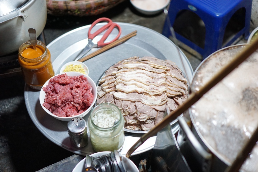 Gánh hàng đơn giản với nồi nước dùng, nồi sốt vang, đĩa thịt bò