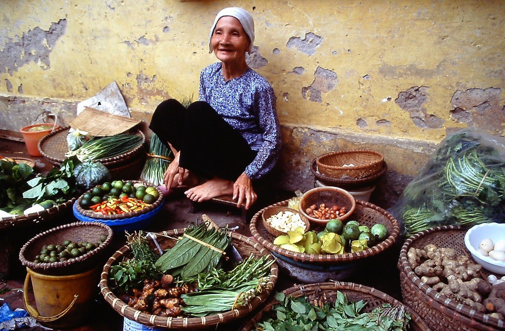 Cụ bà bán rau quả ở chợ cóc.