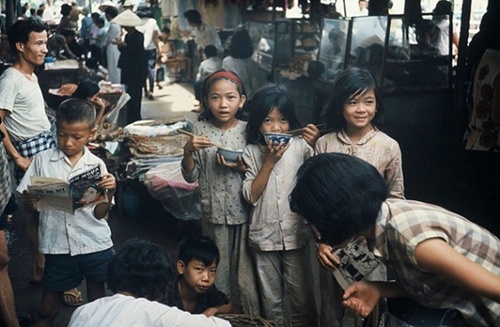 Em bé Sài Gòn xinh xắn, hồn nhiên ăn uống trong một khu chợ xưa.